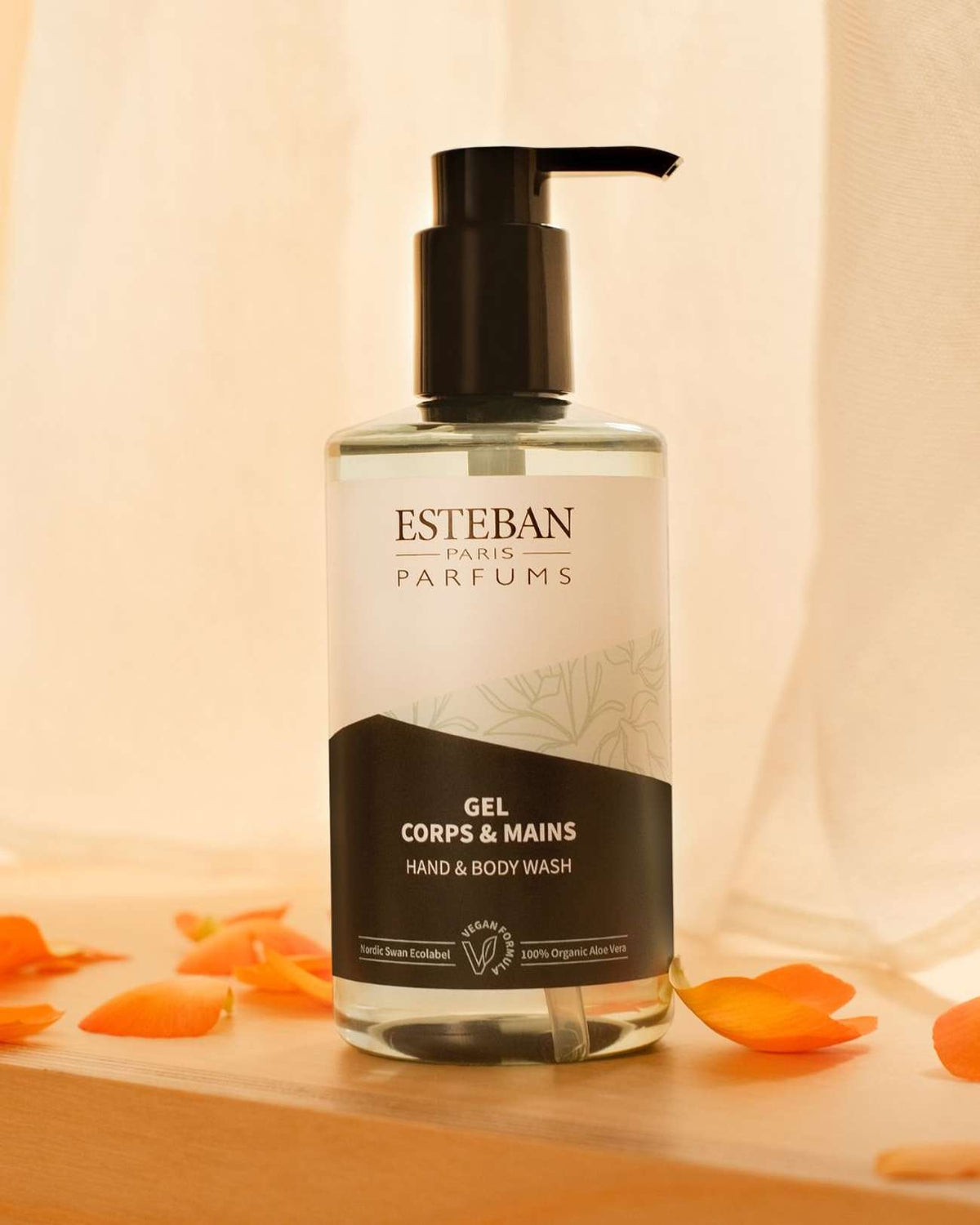 Gel douche corps et mains 300ml sur une table avec des pétales de fleurs orange